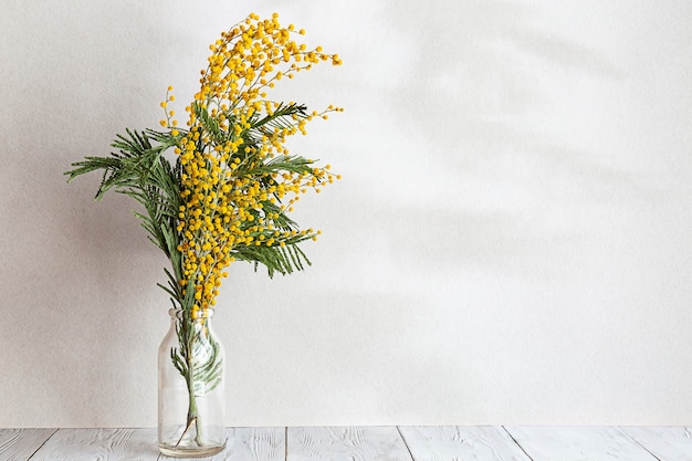 Un bouquet de fleurs de mimosa dans un vase en verre