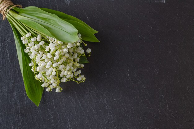 Bouquet de fleurs de muguet sur fond sombre, copie espace, selective focus