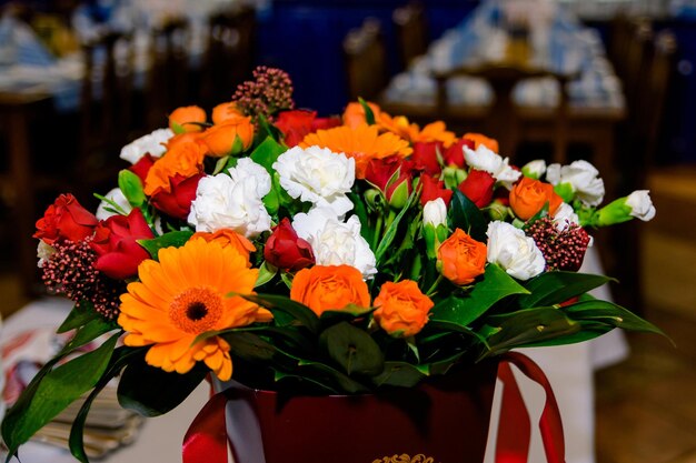 bouquet de fleurs orange et blanches dans une boîte cadeau