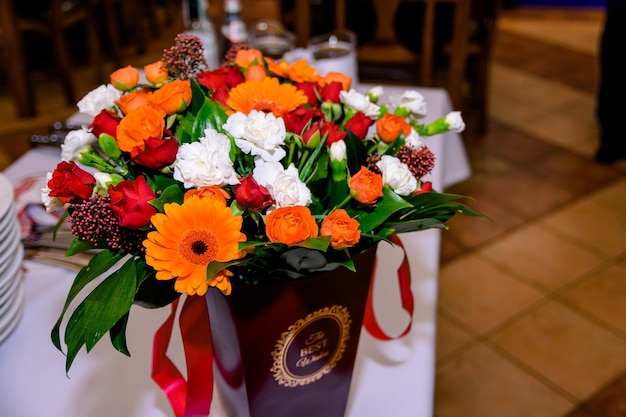 Bouquet de fleurs oranges et blanches dans une boîte cadeau