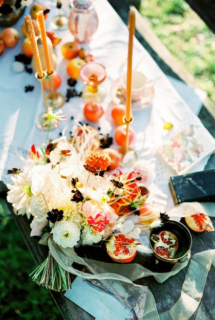 Bouquet de fleurs se trouve sur une table dressée à côté de bougies