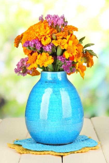 Photo bouquet de fleurs de souci dans un vase sur une table en bois sur fond naturel