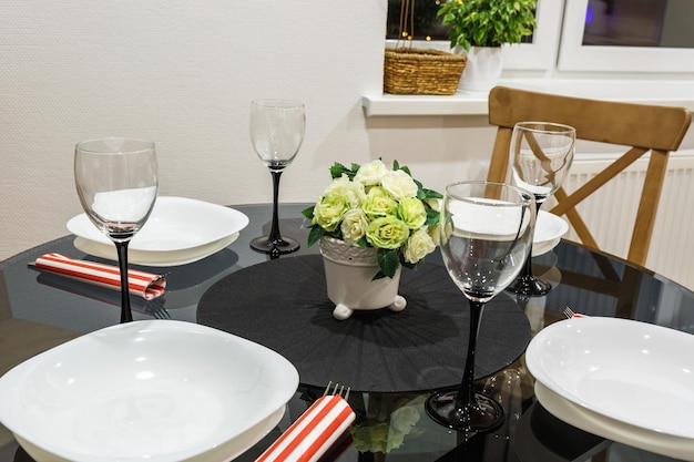 Bouquet de fleurs sur une table avec couverts sur quatre personnes