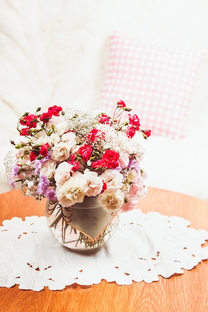 Bouquet de fleurs sur la table près du canapé avec un oreiller