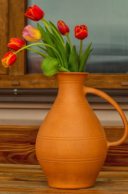 bouquet de fleurs de tulipes dans un vase en argile, à l'extérieur.