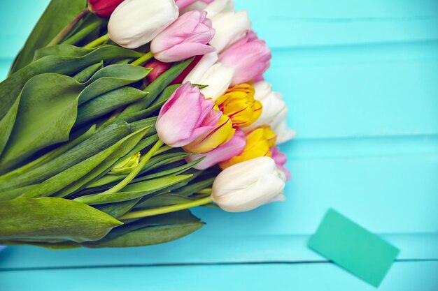 Bouquet de fleurs de tulipes multicolores fraîches sur une vieille table en bois bleue