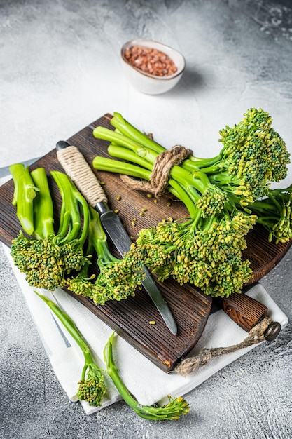 Bouquet frais de pousses de Broccolini sur une planche à découper prêtes pour la cuisson Fond blanc Vue de dessus