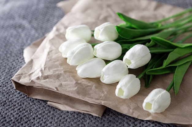 Bouquet frais de tulipes blanches sur papier recyclé sur fond gris