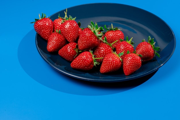 Bouquet de fraise sur plaque sur mur bleu