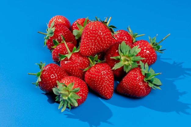 Bouquet de fraises sur mur bleu