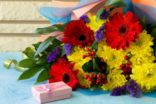 Photo bouquet de gerbera avec chrysanthèmes et présent.