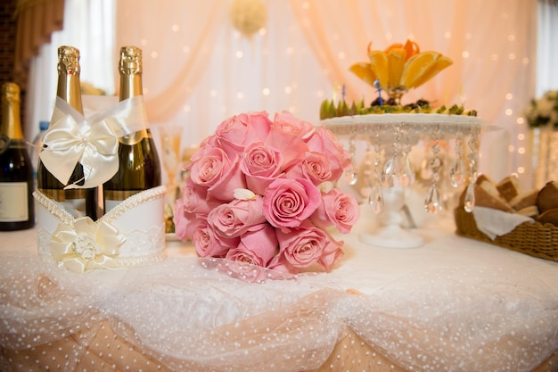 Bouquet de grandes roses roses sur la table des jeunes mariés