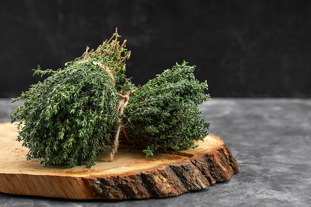 Bouquet d'herbe de thym frais sur une vieille planche de bois.