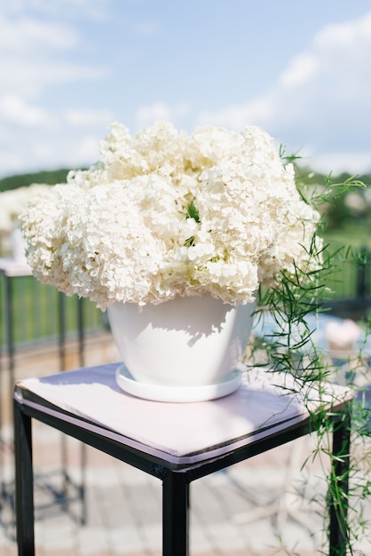 Bouquet d'hortensia blanc dans un vase blanc dans le décor de l'enregistrement de sortie du mariage au mariage