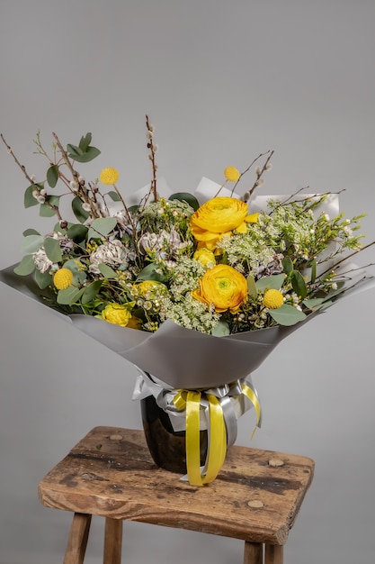 Bouquet jaune de fleurs jaunes et orange sur fond gris gris