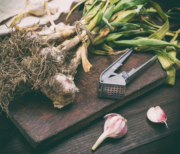 Bouquet de jeune ail sur une planche de bois brune