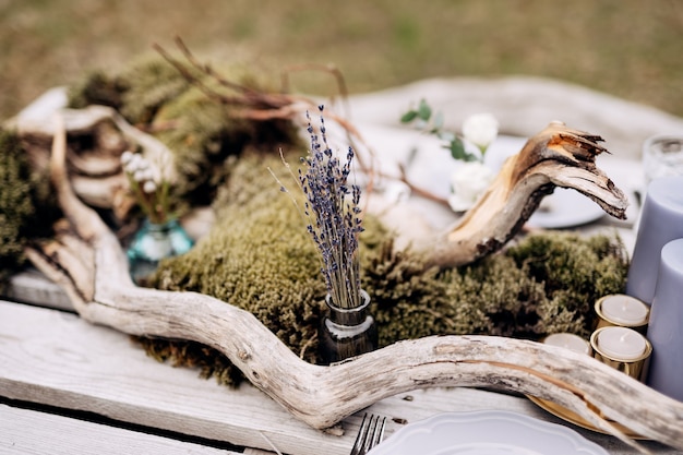 Photo bouquet de lavande séchée dans une petite bouteille lors de la sortie romantique avec des bougies de décoration de table séchées