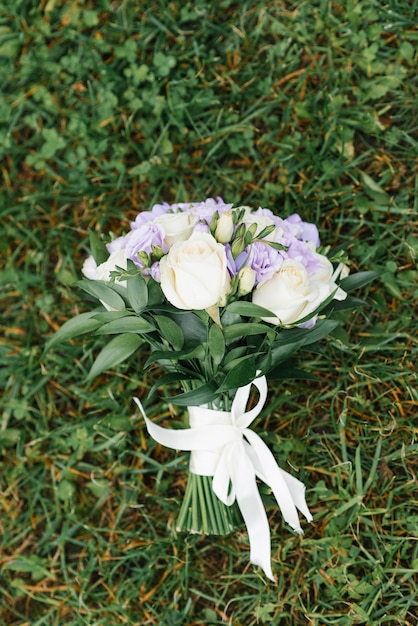 Bouquet de lilas blanc de la mariée se trouve sur l'herbe verte.