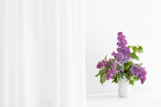 Un bouquet de lilas dans un vase blanc