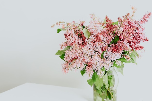 Bouquet de lilas dans un vase sur le printemps blanc