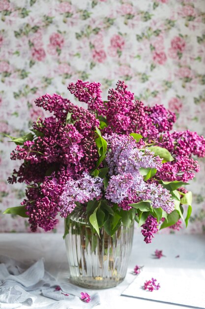 Bouquet de lilas violet dans un vase. Nature morte aux branches fleuries de lilas dans des vases. Maquette de carte de voeux. Espace pour le texte.