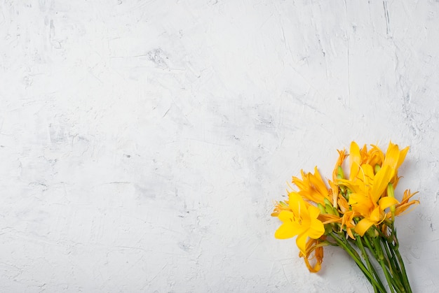 Bouquet de lis jaunes sur béton