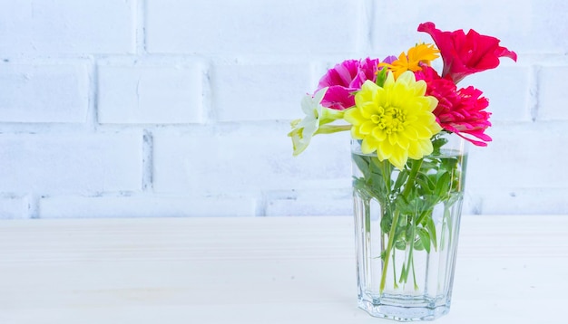 Bouquet lumineux de fleurs de jardin dans un bocal en verre transparent