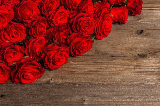 Bouquet luxueux de roses rouges fraîches. Le concept festif pour les mariages, les anniversaires, le 8 mars, la fête des mères ou la Saint-Valentin. Carte de voeux, table en bois vintage