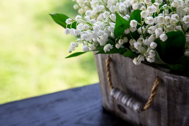 Bouquet de Lys de la vallée dans un panier. fond floral avec des endroits pour votre texte