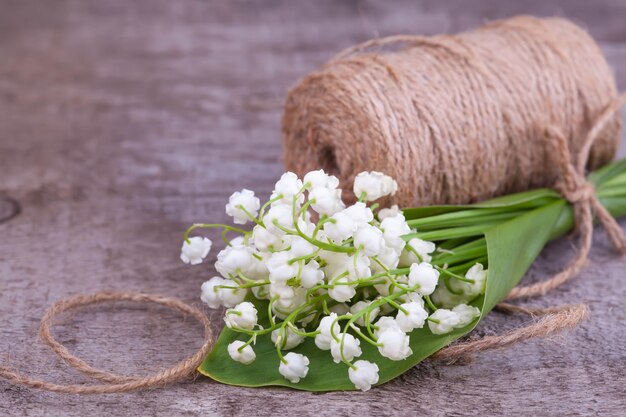 Bouquet de Lys de la vallée sur un vieux fond en bois