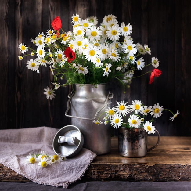 Bouquet marguerites et coquelicots sur une table rustique