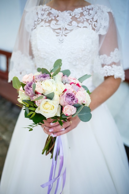 Bouquet de mariage entre les mains des jeunes mariés