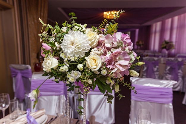 Un bouquet de mariage est posé sur la table au fond de la salle. Bouquet de la mariée.