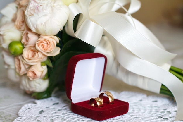 Bouquet de mariage lumineux de fleurs d'été avec des anneaux de mariage
