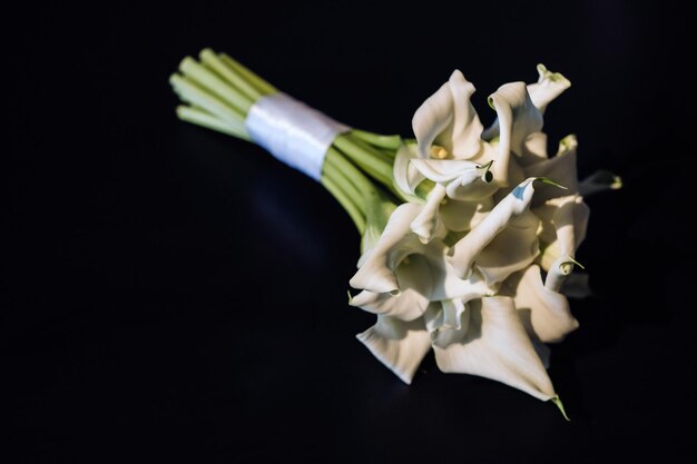 Bouquet de mariage de lys Calla blancs sur fond noir.