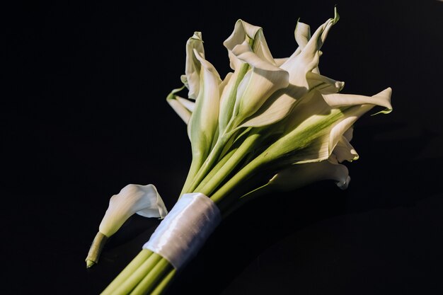 Bouquet de mariage de lys calla blancs sur fond noir