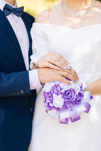 Photo bouquet de mariage et mains avec des bagues de mariage