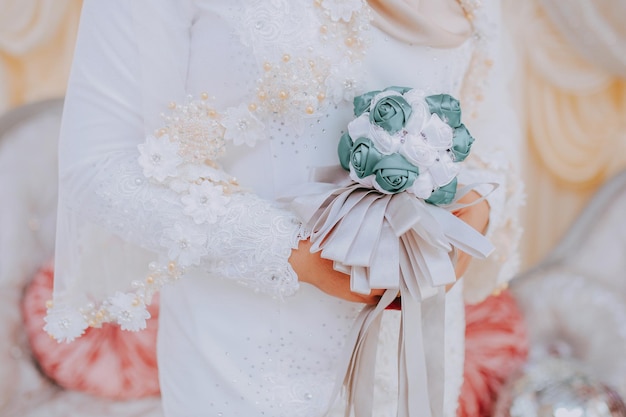 Photo bouquet de mariage malais dans la main de la mariée