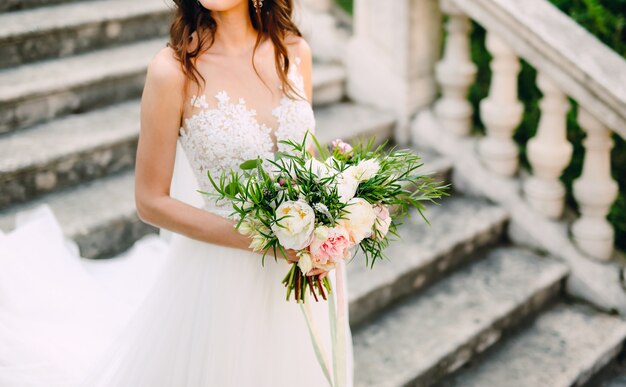 Bouquet de mariage de pivoines dans les mains de la mariée mariage en