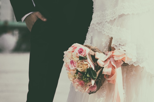 Photo bouquet de mariage rétro avec la fleur dans les mains de la mariée