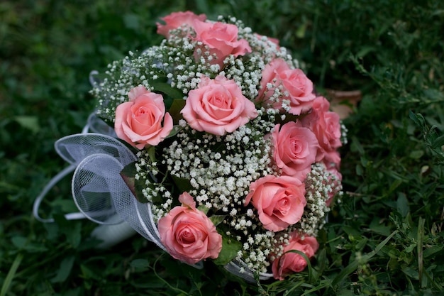 Bouquet de mariée allongé sur l'herbe verte le jour du mariage