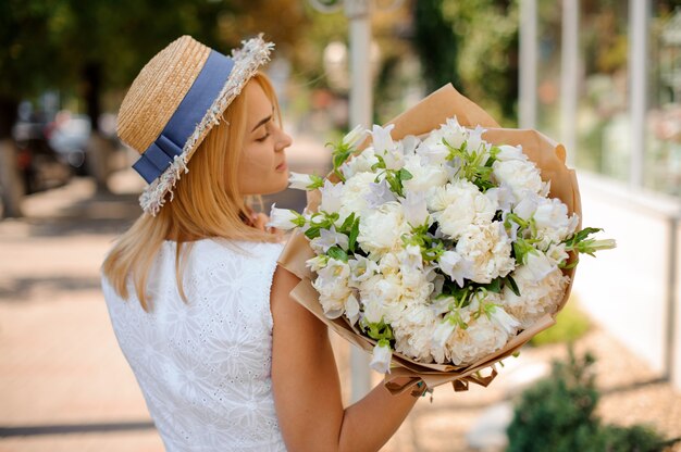 Bouquet de mariée blanc simple entre les mains d'une femme