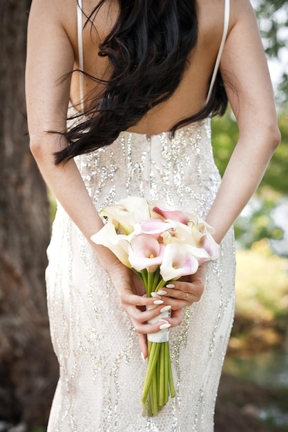 Le bouquet de la mariée Calla pêche dans ses mains 4020