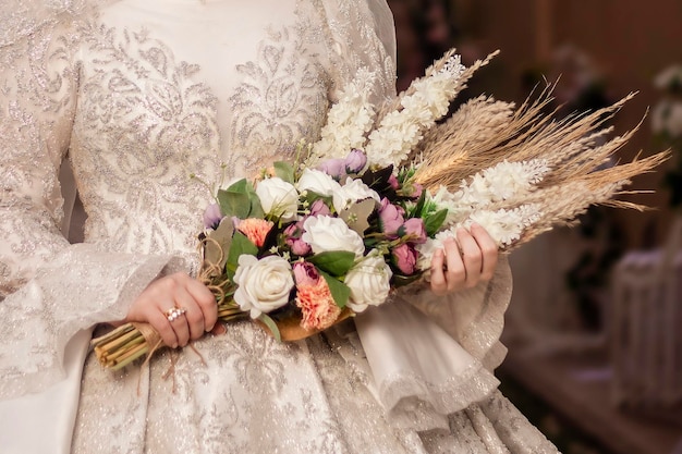 Bouquet de mariée dans la main d'une jeune mariée