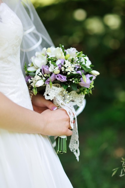 Bouquet de mariée dans les mains de la mariée