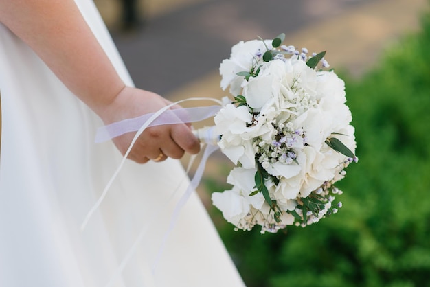 Bouquet de mariée délicat avec hortensia blanc entre les mains de la mariée