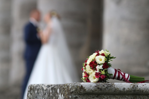 Bouquet de mariée élégant allongé sur la pierre vintage dans le contexte d'un couple d'amoureux