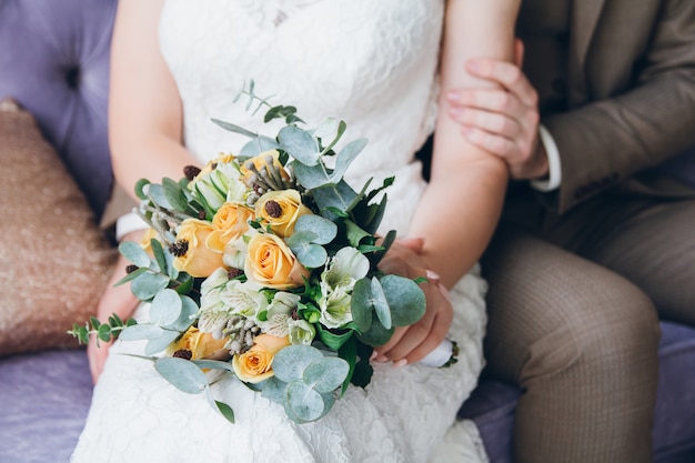 Bouquet de mariée entre les mains de la mariée