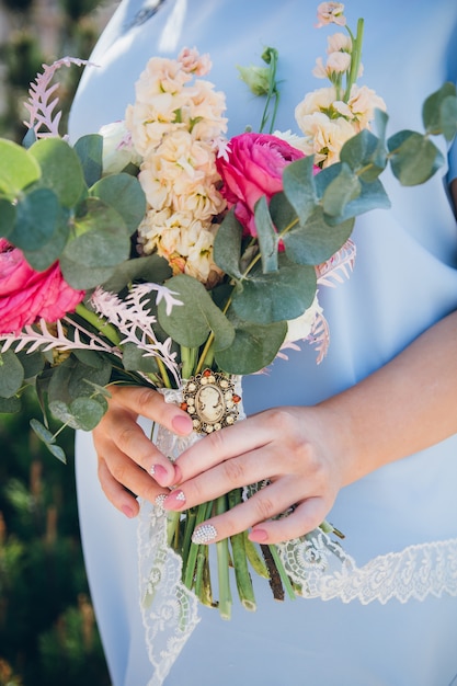 Bouquet de mariée entre les mains de la mariée