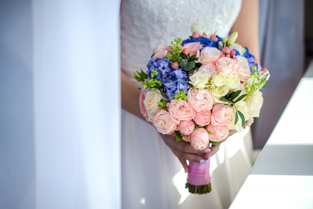 Bouquet de mariée entre les mains de la mariée